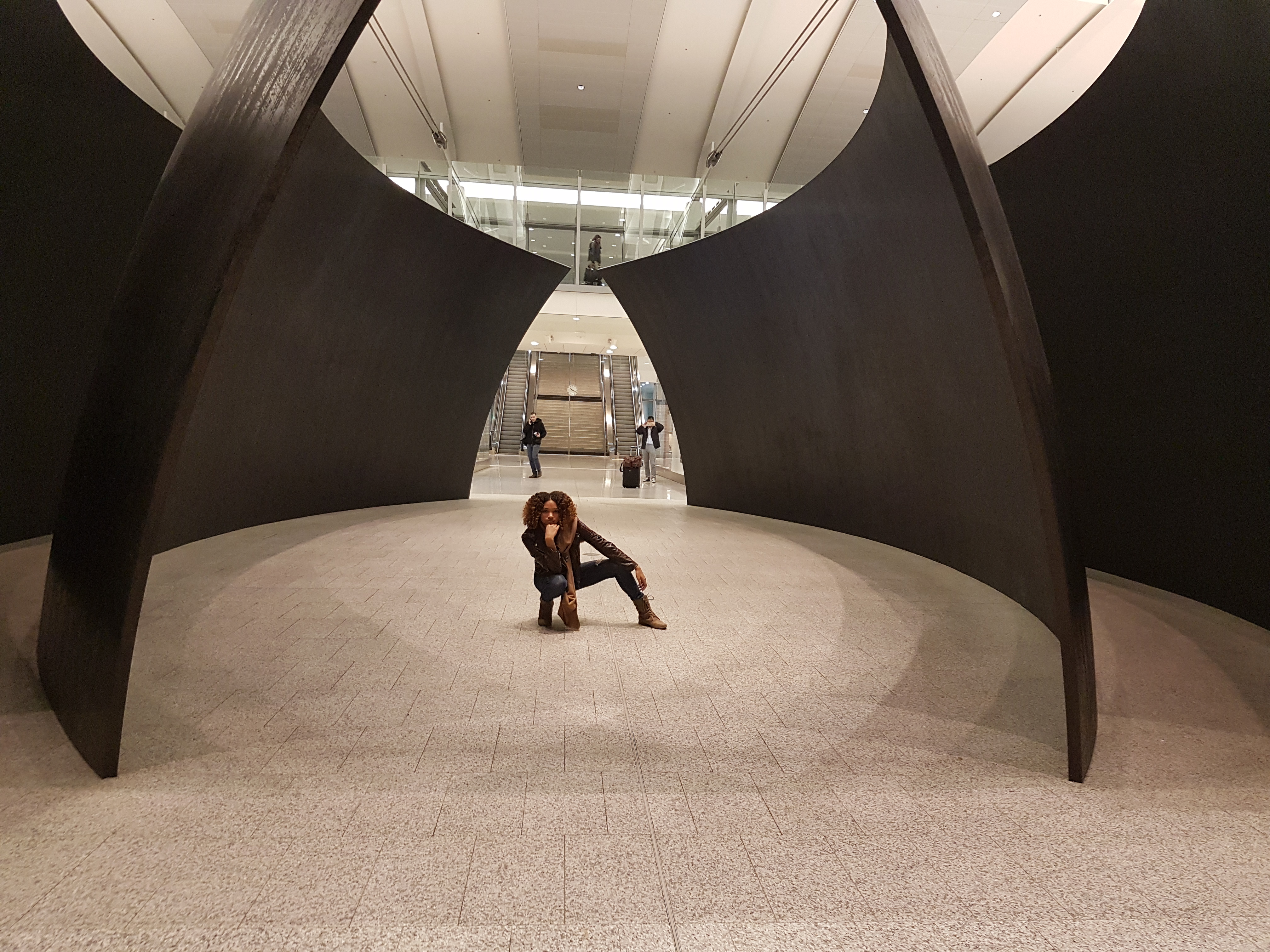 a woman posing between two black walls